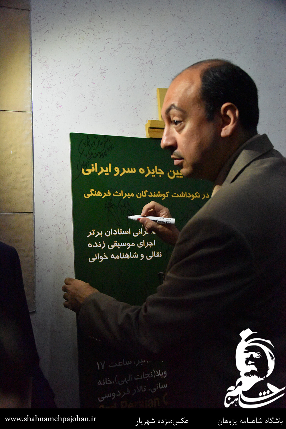 سجاد آیدنلو در حال امضای یادبود جایزه سرو ایرانی
